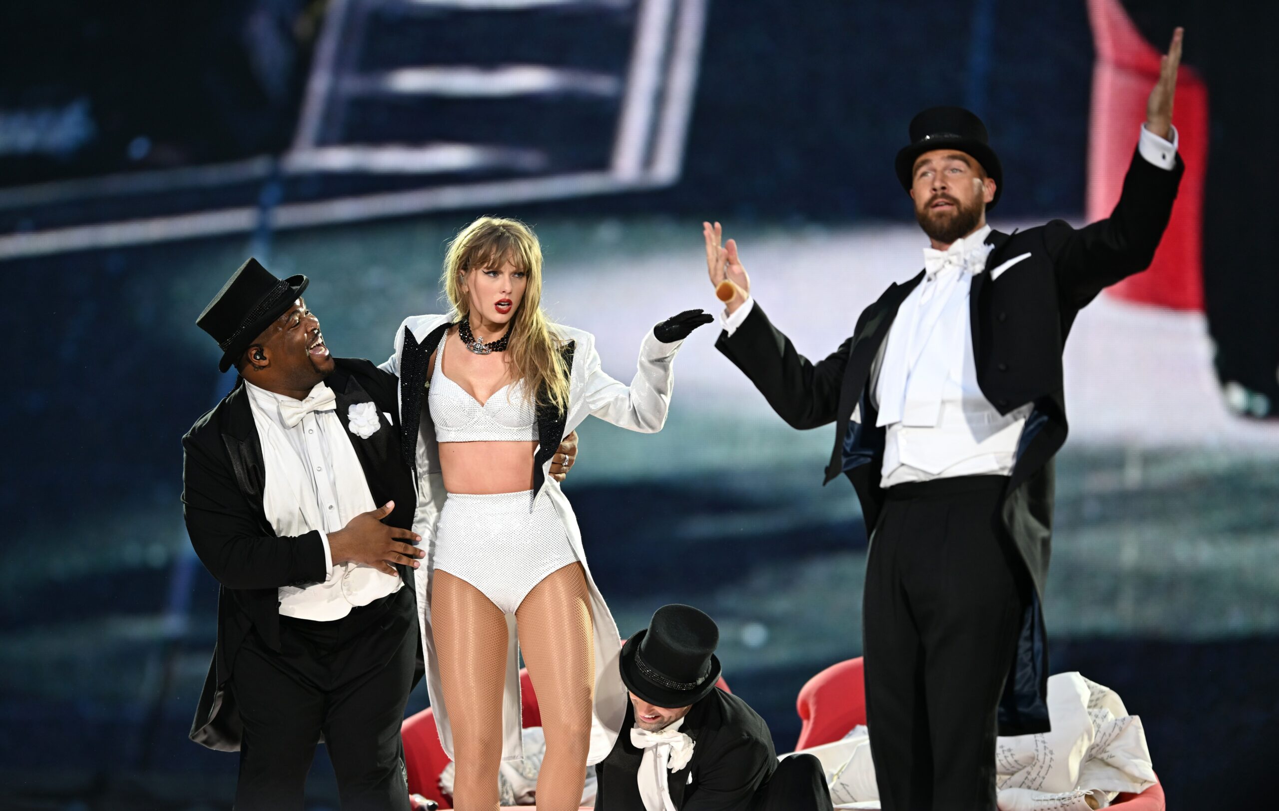 Fãs de Taylor Swift Estão Decifrando o ‘Simbolismo Poético’ da Performace Surpresa de Travis Kelce na Turnê das Eras